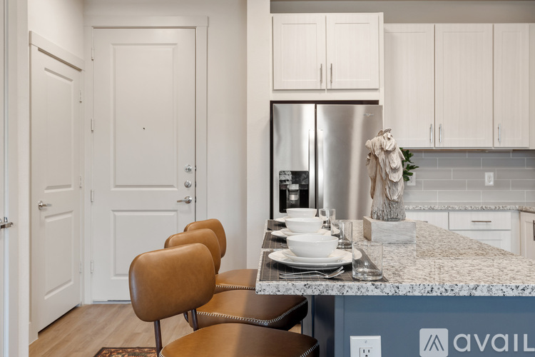 A kitchen with a table and chairs in front of a fridge.