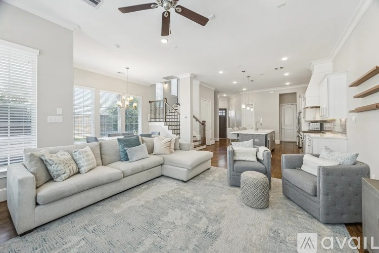A spacious living room with a grey sofa and a grey armchair.