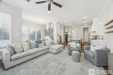 A spacious living room with a grey sofa and a grey armchair.