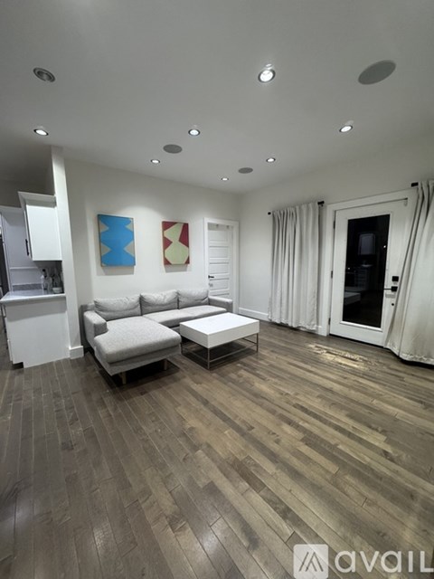 A living room with a couch, a coffee table, and a painting on the wall.
