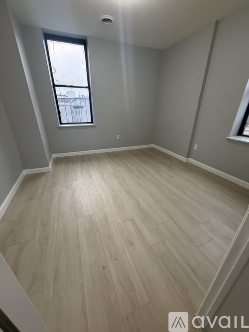 A room with wooden flooring and a window.