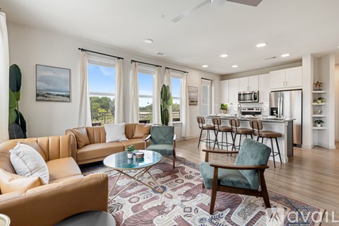 A living room with a brown leather couch, a glass coffee table, and a dining table with chairs.