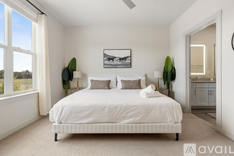A bedroom with a large bed and a painting on the wall.