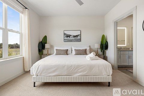 A bedroom with a large bed and a painting on the wall.