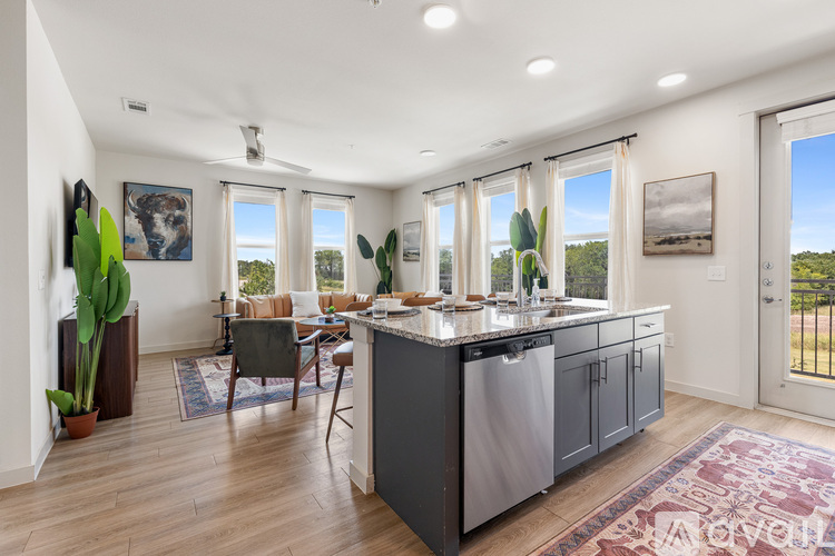 A kitchen with a large island and a dining table with chairs.