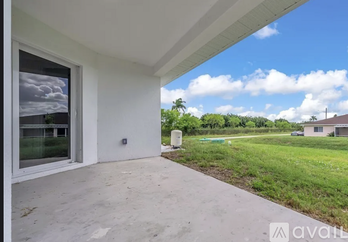 A house with a patio and a view of the sky and trees.