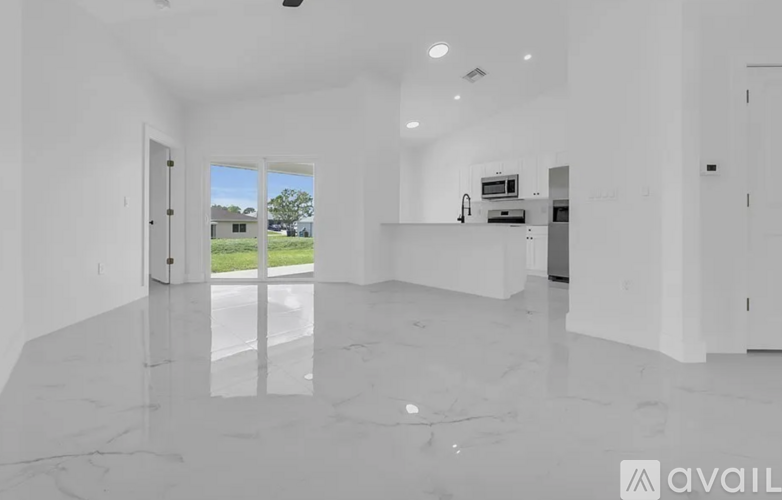 A spacious, empty room with marble flooring and white walls.