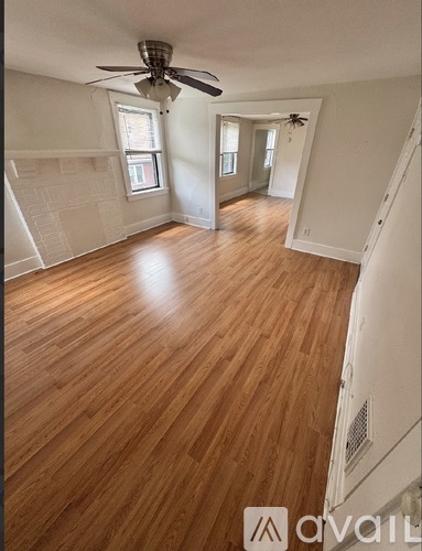A room with wooden floors and a ceiling fan.