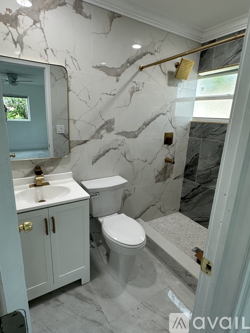 A bathroom with marble walls and a white toilet.