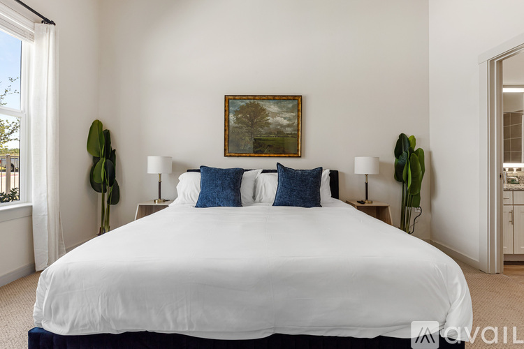 A bedroom with a large bed and a painting on the wall.