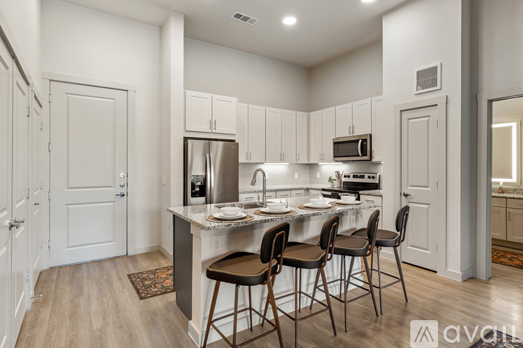 A kitchen with white cabinets and a wooden floor.