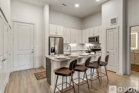 A kitchen with white cabinets and a wooden floor.