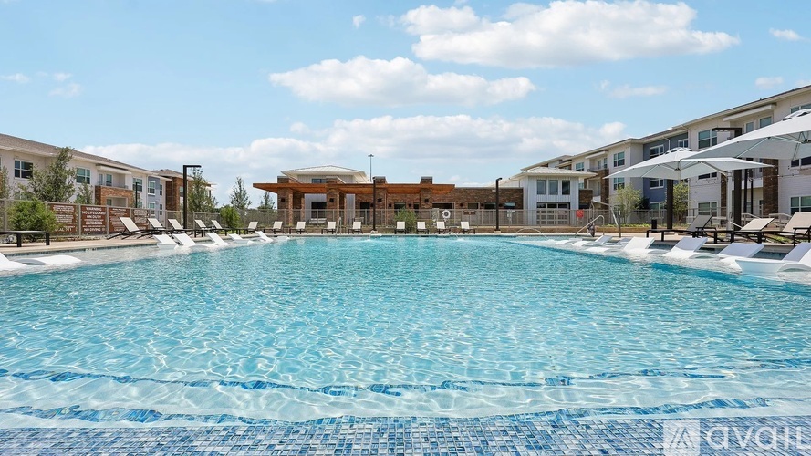 A large swimming pool in front of a building with a clear blue sky above.