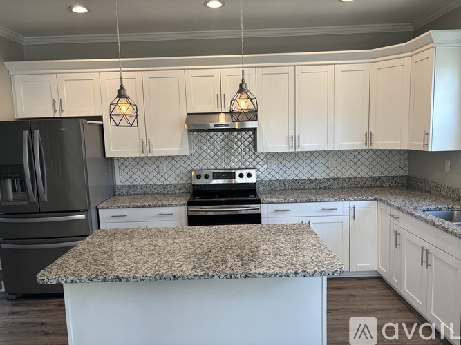 A kitchen with granite countertops and white cabinets.