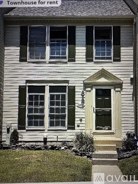 A white house with green shutters is for rent.