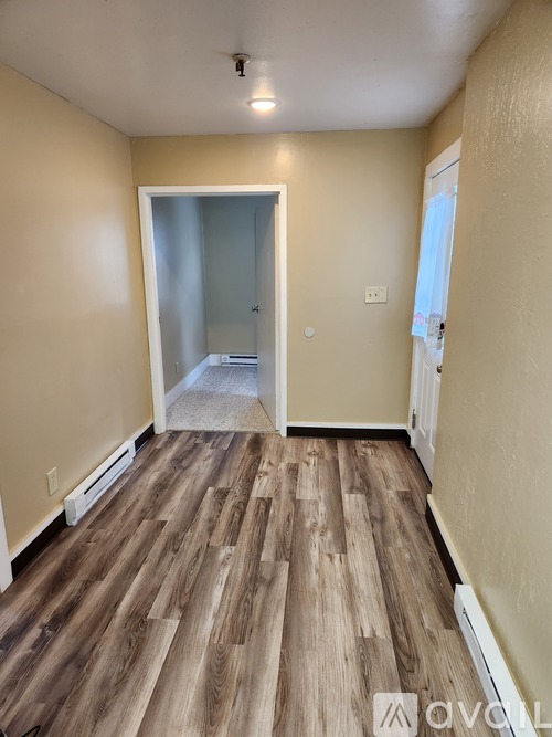 A room with wooden flooring and a white door.