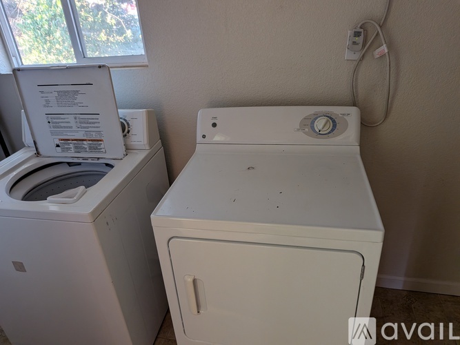 A white washing machine and dryer in a small room.