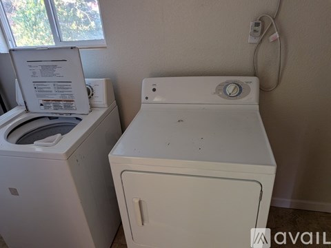 A white washing machine and dryer in a small room.