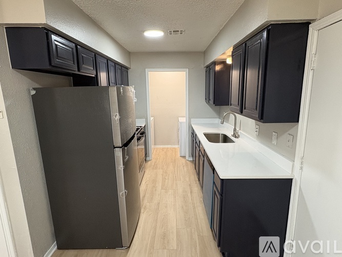 A kitchen with black cabinets and a white counter.