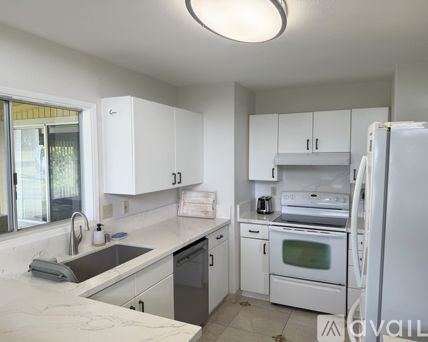 A kitchen with white cabinets and appliances.