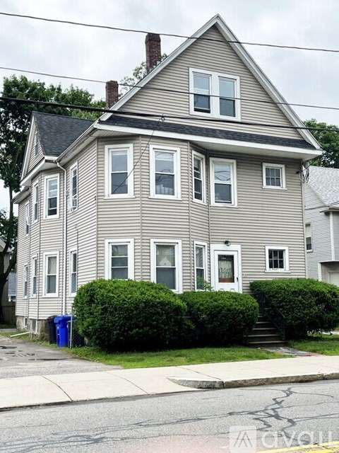 A two-story house with a grey siding and white trim.