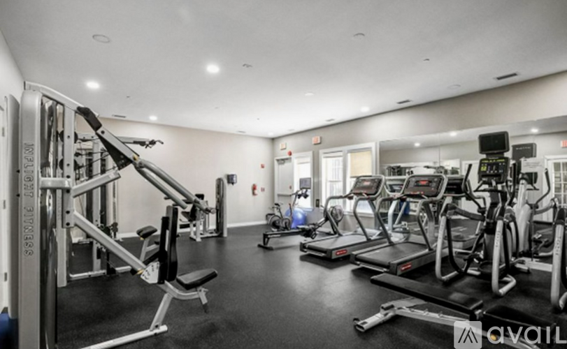 A gym with a variety of equipment including treadmills, weights, and exercise machines.