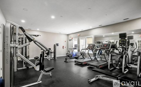 A gym with a variety of equipment including treadmills, weights, and exercise machines.