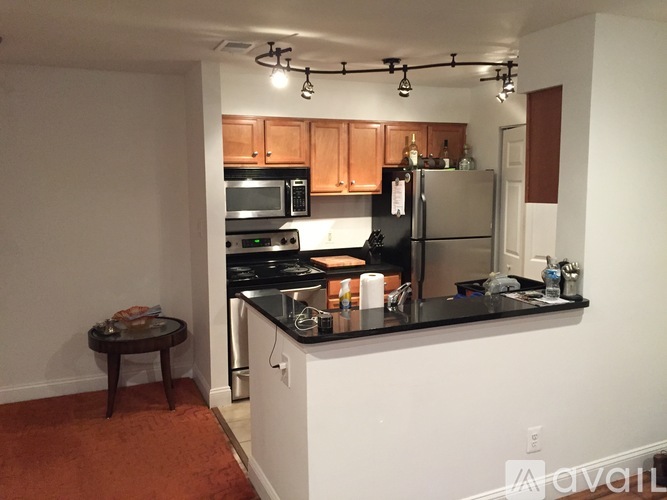 A kitchen with a black counter top and wooden cabinets.