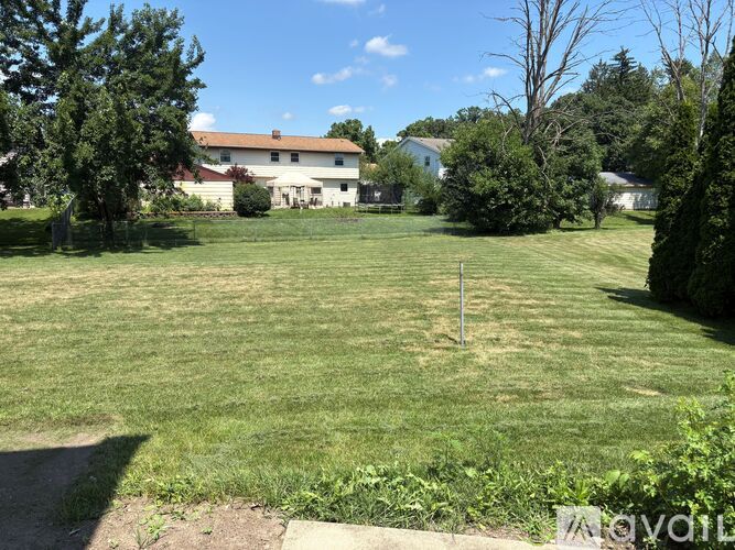 A grassy field with a house in the background.