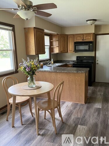 A kitchen with a table and chairs and a fan.