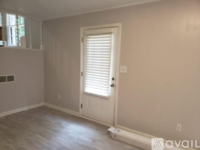 A room with a white door and a window with blinds.