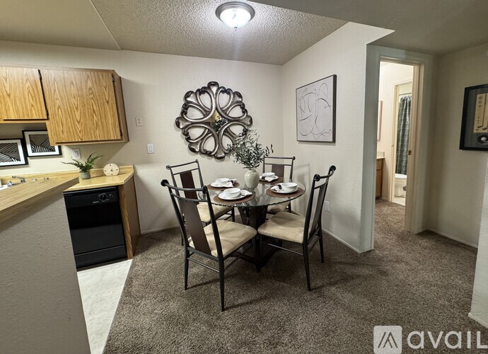 A dining area with a table set for two and a kitchen area with a microwave and oven.