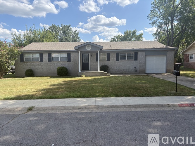 A house with a grey roof and a black door is for sale.