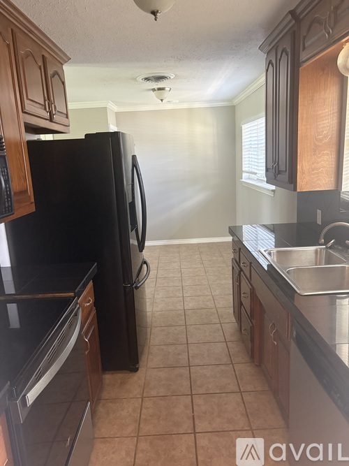 A kitchen with black appliances and wooden cabinets.