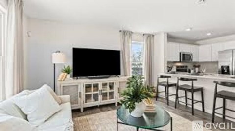 A living room with a white couch and a glass coffee table.