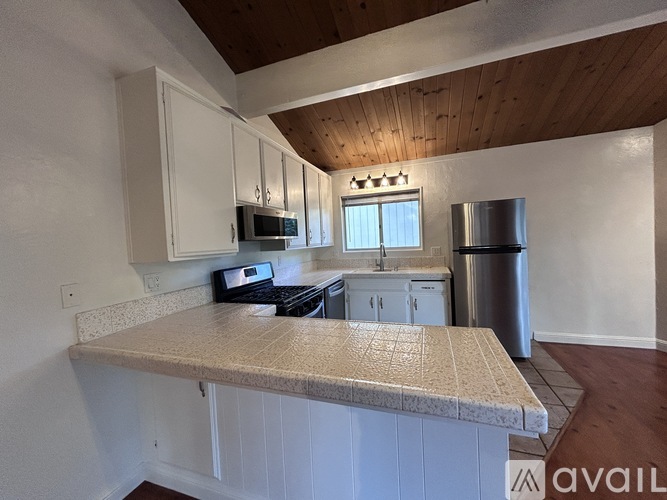 A kitchen with white cabinets and a granite countertop.