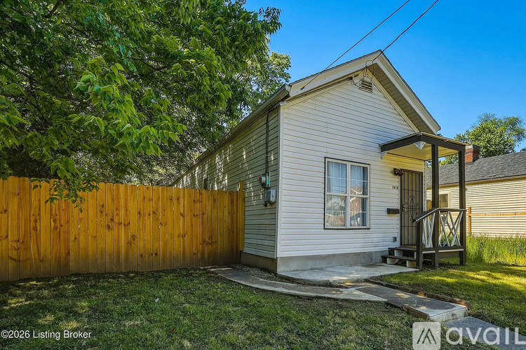 A small house with a wooden fence in front.