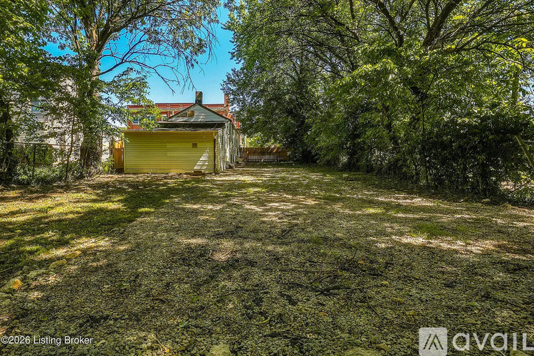 A yellow garage door is closed and the grass is green.