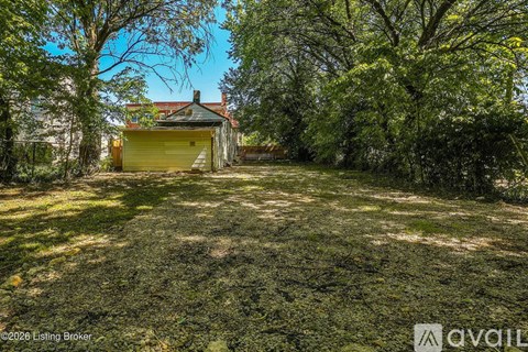 A yellow garage door is closed and the grass is green.