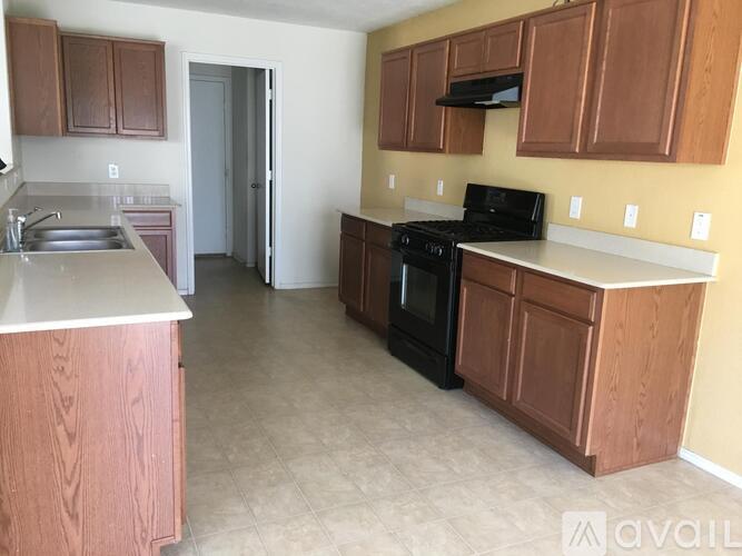 A kitchen with brown cabinets and a black stove top oven.