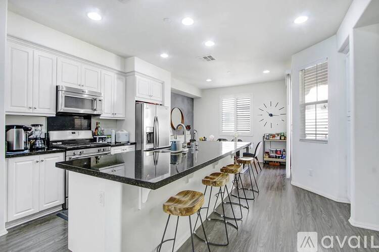 A kitchen with white cabinets and a black countertop.