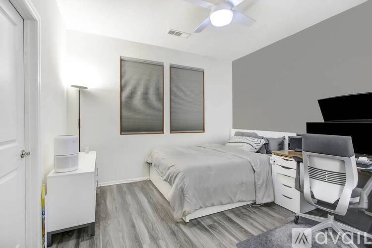 A bedroom with a bed, desk, and chair.