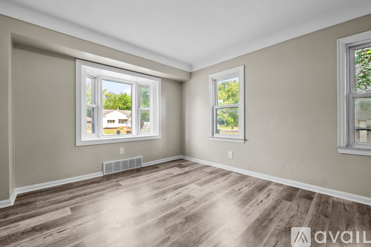 A room with two windows and wooden flooring.