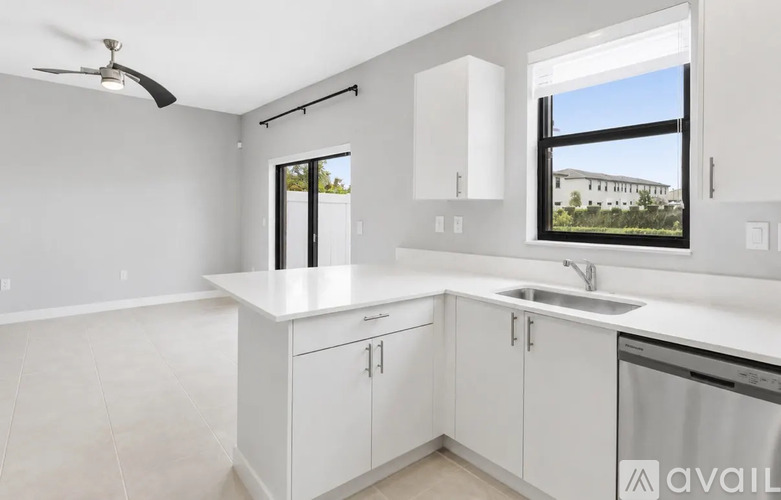 A kitchen with white cabinets and a stainless steel dishwasher.