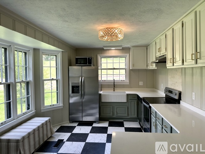 A kitchen with a checkered floor and a refrigerator.
