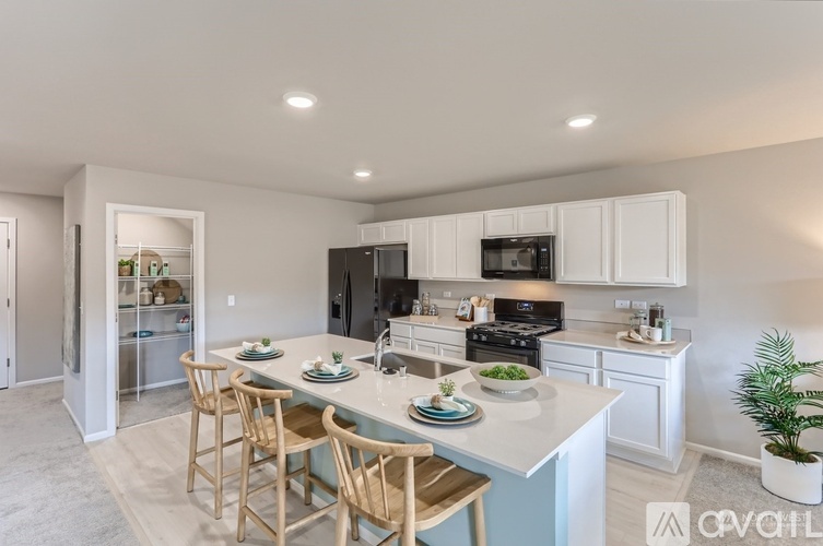 A kitchen with a table and chairs in front of it.