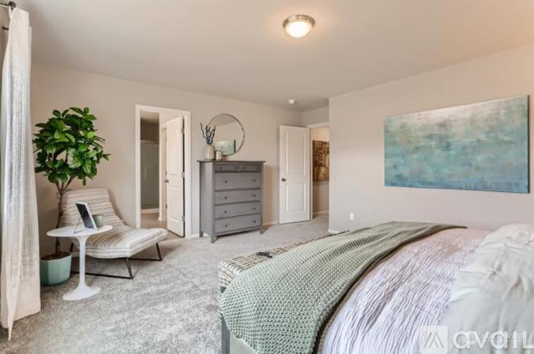 A bedroom with a large bed and a painting on the wall.