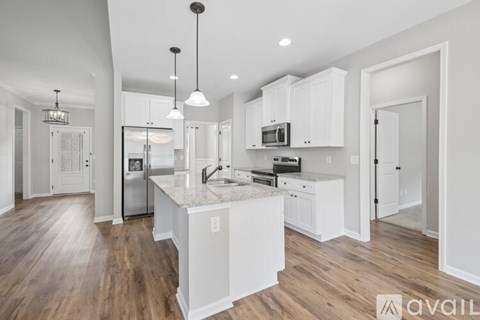 A modern kitchen with white cabinets and a central island.