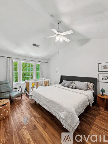 A bedroom with a large bed and a ceiling fan.