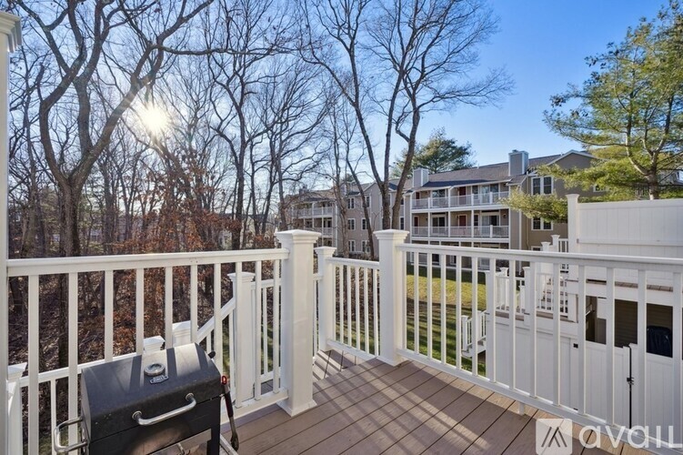 A balcony with a suitcase on it and trees in the background.